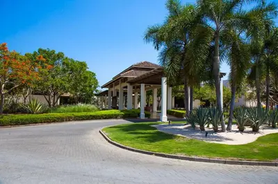 a house with palm trees in front of a driveway at The Luxury Condo at Reserva Conchal, Great Beach in Playa Conchal