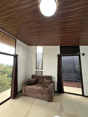 a living room with a couch in a room with windows at Poás Natural in Alajuela City