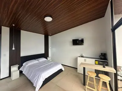 a bedroom with a bed and a table and a desk at Poás Natural in Alajuela City