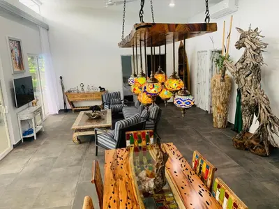a living room filled with wooden tables and chairs at Villa Ballena de Uvita in Uvita