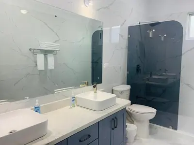a bathroom with a sink and a toilet and a mirror at Villa Ballena de Uvita in Uvita