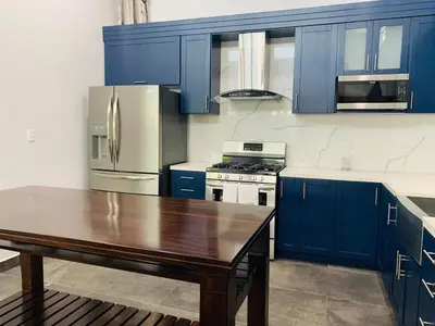 a kitchen with blue cabinets and a wooden table at Villa Ballena de Uvita in Uvita