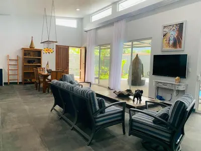 a living room with a dog standing in front of a tv at Villa Ballena de Uvita in Uvita