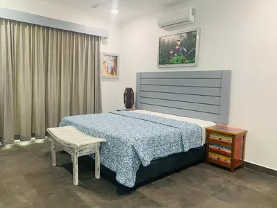 a bedroom with a bed and a table and a chair at Villa Ballena de Uvita in Uvita