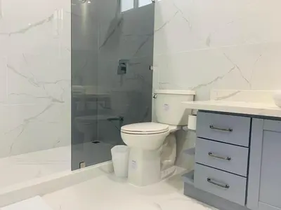 a white bathroom with a toilet and a shower at Villa Ballena de Uvita in Uvita