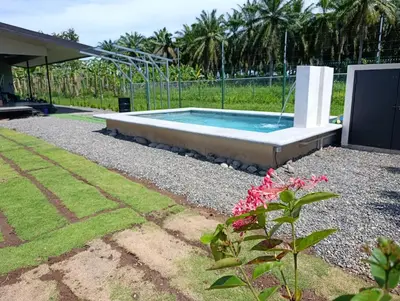 a swimming pool in a yard with a garden at Maracuyá Garden Stanza 1 in Parrita