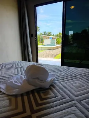 a white sheet on a bed with a window at Maracuyá Garden Stanza 1 in Parrita