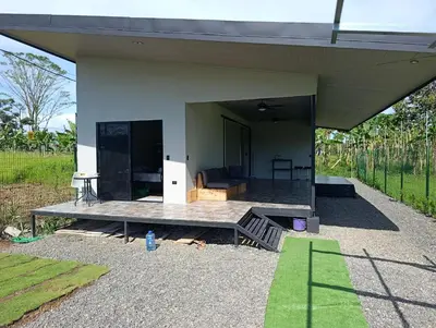 a house with a porch with a table in front of it at Maracuyá Garden Stanza 1 in Parrita
