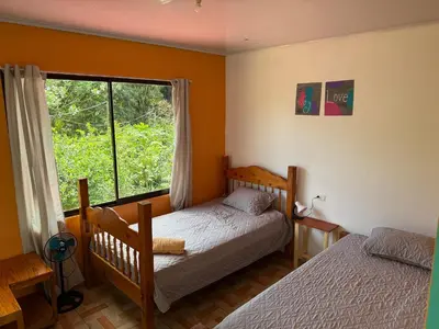 a bedroom with two beds and a window at NeyHouse in Sarapiquí