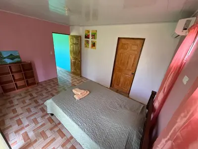 a bedroom with a bed and a door at NeyHouse in Sarapiquí