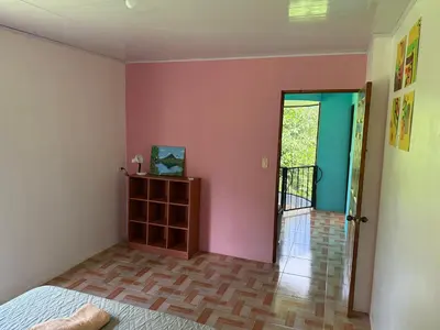 a bedroom with pink walls and a wooden floor at NeyHouse in Sarapiquí