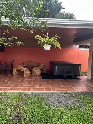 a patio with a tub and a table and a plant at Casa Vista al Volcan, La Fortuna in Fortuna