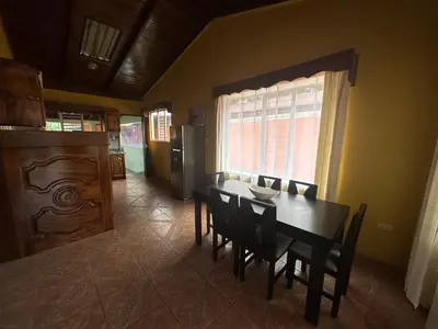 a dining room with a table and chairs and a window at Casa Vista al Volcan, La Fortuna in Fortuna