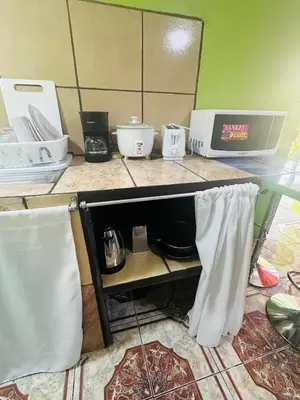 a kitchen counter with a shelf with appliances on it at Paraíso Natural in Quepos