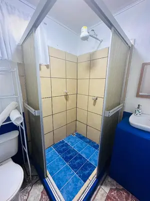 a bathroom with a shower with a toilet and a sink at Paraíso Natural in Quepos