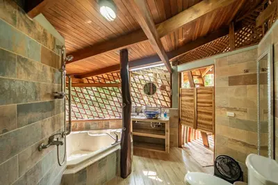 a bathroom with a bath tub and a sink at Samara Tarantela, Treehouse in Sámara