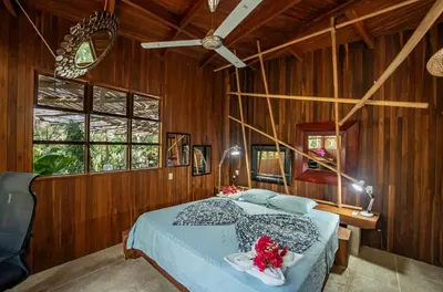 a bedroom with a bed in a wooden wall at Samara Tarantela, Treehouse in Sámara