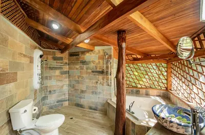 a bathroom with a toilet and a bath tub at Samara Tarantela, Treehouse in Sámara