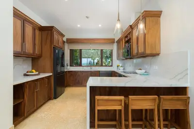 a kitchen with wooden cabinets and a white counter top at El Sueño in Nacascolo