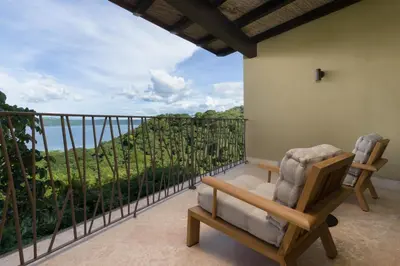a balcony with a chair and a view of the ocean at El Sueño in Nacascolo