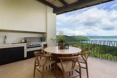 a kitchen with a table and chairs and a balcony at El Sueño in Nacascolo