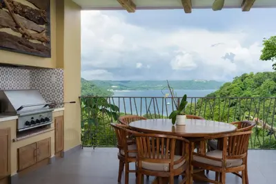 a kitchen with a table and chairs and a balcony with a view at La Experiencia in Nacascolo