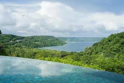a swimming pool with a view of a lake at La Experiencia in Nacascolo