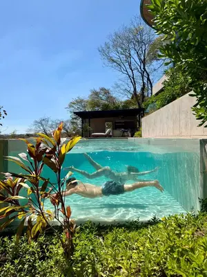 a man laying in a swimming pool in a house at Villa Coral in Nacascolo
