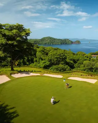 two people are playing golf on a golf course at Villa Tortuga in Nacascolo