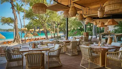 a restaurant with tables and chairs on a deck at Villa Tortuga in Nacascolo