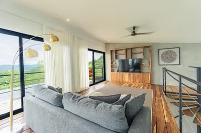 a living room with a couch and a tv at Villa with Stunning Isla Tortuga Ocean View, Near Curu Park & Ferry in Blue Zone in Paquera