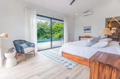 a bedroom with a bed and a large window at Villa with Stunning Isla Tortuga Ocean View, Near Curu Park & Ferry in Blue Zone in Paquera