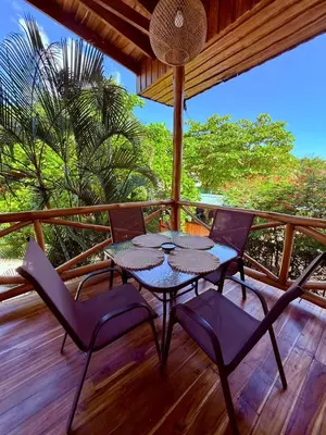 a patio with a table and chairs on a deck at Villas Solar in Santa Teresa Beach