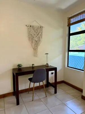 a desk with a chair in a room with a window at Villas Solar in Santa Teresa Beach