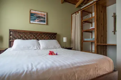 a bedroom with a white bed with a red ribbon on it at Villas Solar in Santa Teresa Beach