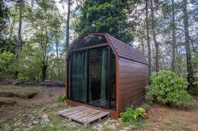 a small cabin in the middle of a forest at Cabaña English Evergreen in Jardín