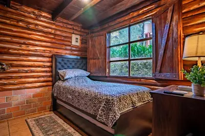 a bedroom with a bed in a log cabin at Cabaña English Evergreen in Jardín