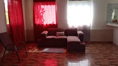 a living room with a couch and red curtains at Hospedaje Herradura de Rivas in Rivas