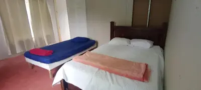 a bedroom with two beds with blue and red sheets at Hospedaje Herradura de Rivas in Rivas