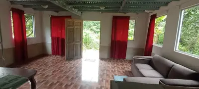 a living room with red curtains and a couch at Hospedaje Herradura de Rivas in Rivas