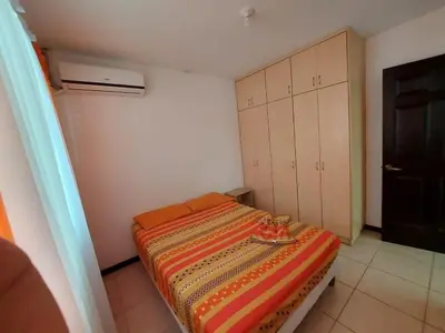 a small bedroom with a bed with a striped blanket at An ideal place to share with family and friends in Bejuco