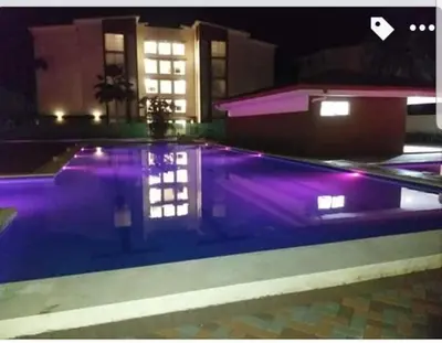 a person standing in a swimming pool at night at An ideal place to share with family and friends in Bejuco