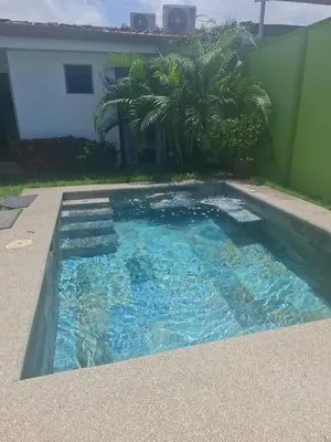 a swimming pool with blue water and palm trees at An ideal place to share with family and friends in Bejuco