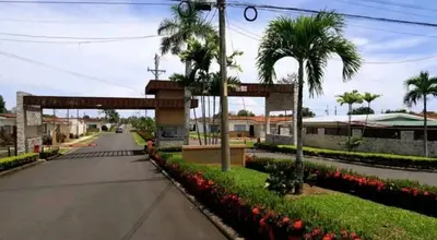 a street with a gate and palm trees and flowers at An ideal place to share with family and friends in Bejuco