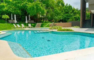 a swimming pool with a fountain in a yard at Mar y Selva at Naumi, Ocean Views & Beach Club in Sardinal