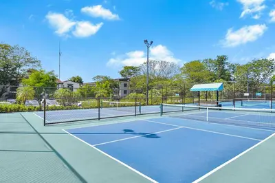 a tennis court with two tennis courts at Mar y Selva at Naumi, Ocean Views & Beach Club in Sardinal