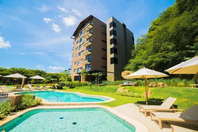 a hotel with a swimming pool and a building at Sol Pacífico at Naumi, Ocean Views & Beach Club in Sardinal