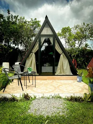 a tent with a table and a chair in front of it at Tilawa La Fortuna Glamping in Ángeles