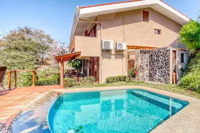 a house with a swimming pool in front of a house at Bahia Pez Vela Villa at 26 in Ocotal