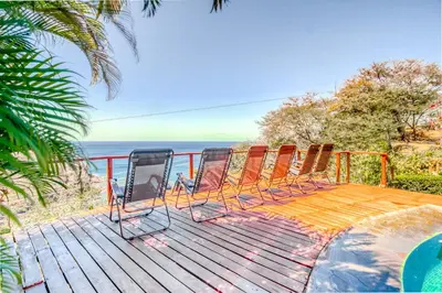 a group of chairs sitting on a deck overlooking the ocean at Bahia Pez Vela Villa at 26 in Ocotal